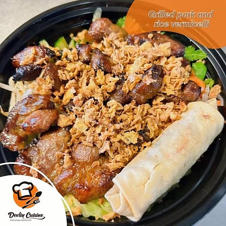 Grilled pork over rice vermicelli with crispy shallots and a spring roll